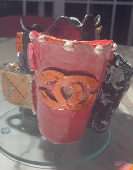 Inspired by Chanel, a red, black, and gold ceramic vase for cosmetic utensils